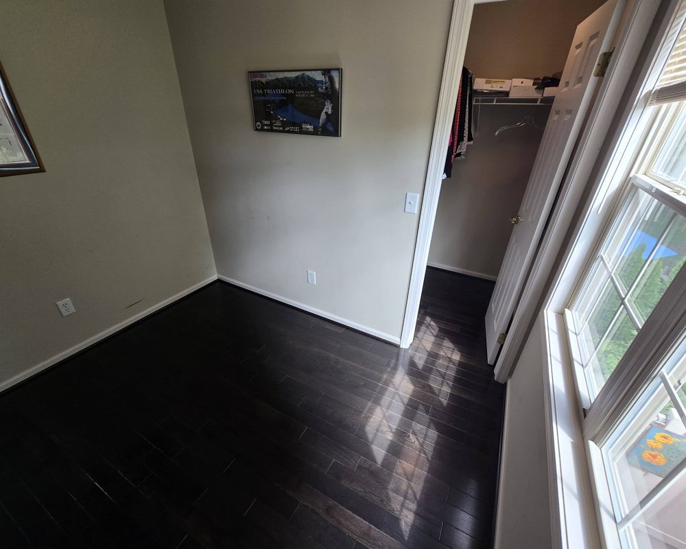 Room with dark espresso hardwood after the carpet was removed