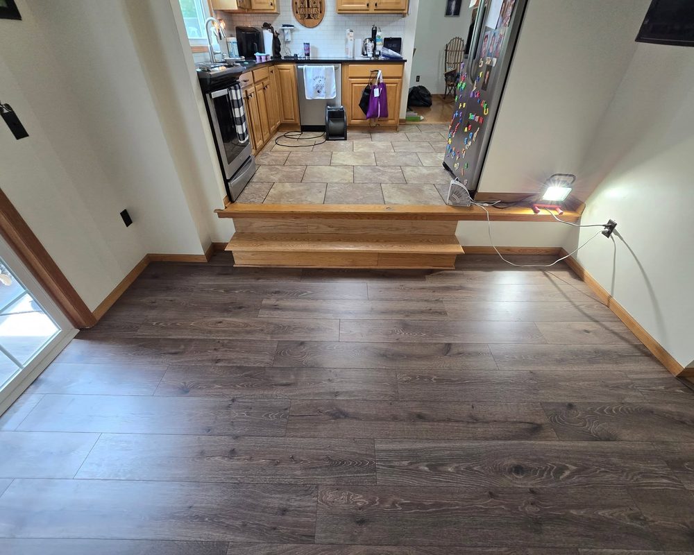 Vinyl plank flooring in a hallway leading to a kitchen
